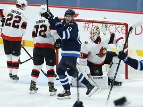 Winnipeg Jets centre Pierre-Luc Dubois (centre) and Kyle Connor celebrate a goal from Dylan DeMelo (not shown) against the Ottawa Senators Thursday. Kevin King/Winnipeg Sun