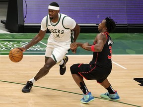 The Raptors' OG Anunoby (right) guards Bobby Portis of the Milwaukee Bucks on Tuesday night. Anunoby was back in the linup after missing 10 games.