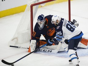 Edmonton Oilers goalie Mike Smith (41) watches the Winnipeg Jets' Mathieu Perreault (85) on Wednesday, Feb. 17, 2021, in Edmonton.