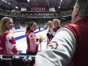 Team Canada skip Chelsea Carey, from left to right, lead Rachel Brown, second Dana Ferguson and third Sarah Wilkes speak to their coach Dan Carey during last year's Scotties Tournament of Hearts in Moose Jaw, Sask., in this photo from February 2020.