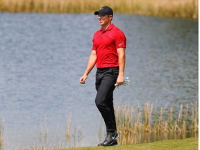 Rory McIlroy walks to the second green wearing red and black honoring Tiger Woods during the final round of World Golf Championships at The Concession golf tournament at The Concession Golf Club.