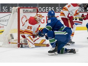 Calgary Flames goalie Jacob Markstrom makes a save on Vancouver Canucks forward Adam Gaudette in the first period at Rogers Arena on Saturday night.