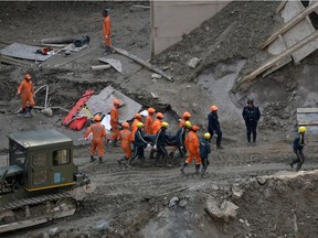Members of National Disaster Response Force (NDRF) and State Disaster Response Fund (SDRF) carry the body of a victim after recovering it from the debris inside a tunnel during a rescue operation after a flash flood swept a mountain valley destroying dams and bridges, in Tapovan in the northern state of Uttarakhand, India, February 14, 2021.