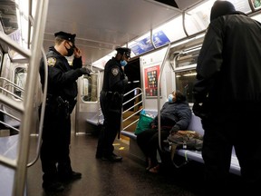 New York City Police Department (NYPD) officers remove a person from a carriage as the MTA Subway closed overnight for cleaning and disinfecting during the outbreak of the coronavirus disease (COVID-19) in the Brooklyn borough of New York City, U.S., May 7, 2020.