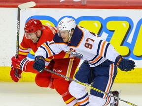 The Calgary Flames’ Mark Giordano is in a foot race with the Edmonton Oilers’ Connor McDavid at the Saddledome in Calgary on Friday, Feb. 19, 2021.