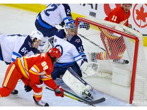 Calgary Flames forward Andrew Mangiapane scores a goal against Connor Hellebuyck of the Winnipeg Jets during NHL hockey in Calgary late Tuesday night.