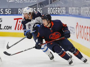 Edmonton Oilers forward Kailer Yamamoto (56) and Winnipeg Jets defencemen Tucker Poolman (3) look for loose puck during the third period at Rogers Place. Perry Nelson-USA TODAY Sports