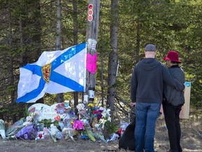 A couple pay their respects at a roadblock in Portapique, N.S. on Wednesday, April 22, 2020.