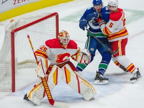 Canucks winger J.T. Miller battles to gain position on Flames defenceman Mark Giordano.