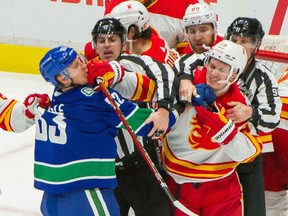 Vancouver Canucks' Jay Beagle and Calgary Flames' Matthew Tkachuk mix it up during NHL action at Rogers Arena in Vancouver on Feb. 11.