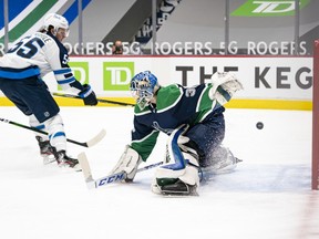 Mark Scheifele of the Winnipeg Jets scores on goalie Thatcher Demko of the Vancouver Canucks for 1-0 lead in the first period at Rogers Arena on Friday, Feb. 19, 2021 in Vancouver.