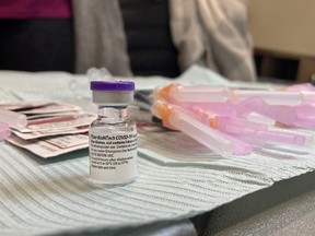 A vial of Pfizer-BioNTech COVID-19 vaccine sits on a work station thawing in preparation for being administered during the first day of vaccinations at the Strathcona Paper Centre vaccine clinic in Napanee on Monday, March 15, 2021.