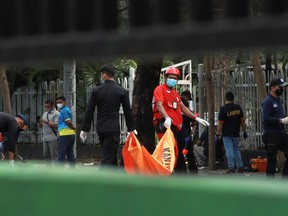 Indonesian Red Cross personnel carry a body bag following an explosion outside a Catholic church in Makassar, South Sulawesi province, Indonesia, March 28, 2021.