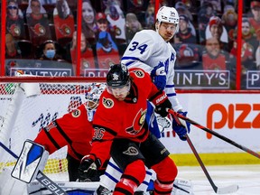 Senators center Colin White (36) checks Toronto Maple Leafs centre Auston Matthews (34) in front of goaltender Anton Forsberg (31) during second period on Thursday night.