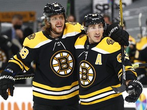 David Pastrnak, left, of the Boston Bruins celebrates with Brad Marchand after scoring a goal against the New York Rangers during the first period at TD Garden on March 11, 2021 in Boston.