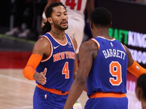 Derrick Rose, left, of the New York Knicks celebrates with RJ Barrett during the second half while playing the Detroit Pistons at Little Caesars Arena on Feb. 28, 2021 in Detroit, Mich.