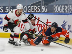 Edmonton Oilers forward Jesse Puljujarvi (13) and Ottawa Senators defencemen Artem Zub (2) battle for a loose puck at Rogers Place on March 8, 2021.