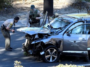 Los Angeles County Sheriff's Deputies inspect the vehicle of golfer Tiger Woods after it was involved in a single-vehicle accident in Los Angeles February 23, 2021.