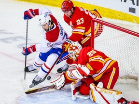 Flames goaltender Jacob Markstrom makes a save as Canadiens' left wing Phillip Danault tries to score during the third period at Scotiabank Saddledome in Calgary on Saturday, March 13, 2021.