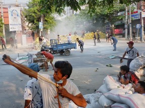 A man uses a slingshot during the security force crack down on anti-coup protesters in Mandalay, Myanmar March 14, 2021.