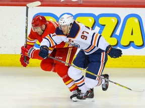 The Calgary Flames’ Mark Giordano gets in a foot race with the Edmonton OIlers’ Connor McDavid at the Saddledome in Calgary on Friday, Feb. 19, 2021.