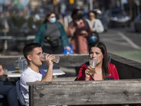 Shayne DeSilva and Brianna Rushlow enjoy the patio at Rivals Sports Pub along Danforth Ave. in Toronto, Ont., on Saturday, March 20, 2021.