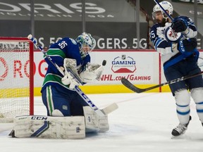 VANCOUVER, BC - March 24, 2021 - Vancouver Canucks Thatcher Demko makes a save in front of Winnipeg Jets Mathieu Perreault during NHL hockey at Rogers Arena in Vancouver, BC, March 24, 2021. Photo by Arlen Redekop / Vancouver Sun / The Province (PNG) (story by reporter) [PNG Merlin Archive]