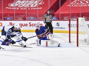 Mathieu Perreault #85 of the Winnipeg Jets scores on goaltender Jake Allen #34 of the Montreal Canadiens during the first period at the Bell Centre on March 4, 2021 in Montreal, Canada.