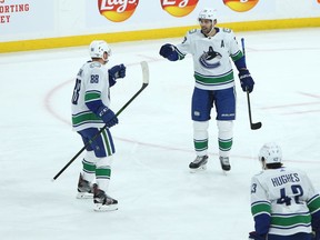 Vancouver Canucks defenceman Nate Schmidt (left) is congratulated for his goal against the Winnipeg Jets in Winnipeg by Brandon Sutter (centre) and Quinn Hughes on Monday, March 1, 2021.