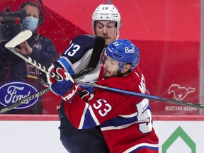 Canadiens' Victor Mete jostles with Jets' Pierre-Luc Dubois during second period at the Bell Centre Thursday night. Mete was benched for the third period in Montreal's 4-2 loss.