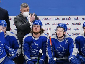 Maple Leafs head coach Sheldon Keefe calls to one of his players as forward William Nylander (88) and forward Zach Hyman (11) look at the scoreboard.