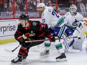 Ottawa Senators winger Brady Tkachuk (7) and Vancouver Canucks defenceman Alexander Edler in front of goaltender Braden Holtby on Monday night at the Canadian Tire Centre.