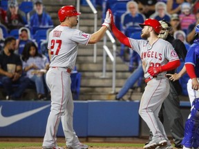 Angels centre fielder Mike Trout (left) meets first baseman Jared Walsh during Friday's win over the Blue Jays.