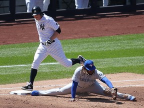 New York Yankees second baseman DJ LeMahieu (26) beats out an infield RBI single despite the efforts of Toronto Blue Jays first baseman Vladimir Guerrero Jr. (27) at Yankee Stadium.