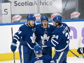 Maple Leafs' Mitchell Marner (centre) celebrates with Auston Matthews (right) after scoring a goal against the Ottawa Senators during the second period at Scotiabank Arena on Saturday, April 10.