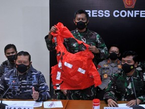 A military personnel holds an escape suit believed to be from the sunken Indonesian Navy KRI Nanggala-402 submarine during a media conference at I Gusti Ngurah Rai Airport in Bali, Indonesia, Sunday, April 25, 2021.