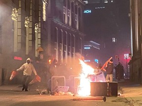 People take part in an anti-curfew protest in Montreal on Sunday April 11, 2021.