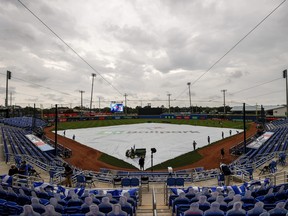 A general view of the grounds crew laying the tarp down on the field in anticipation of approaching inclement weather prior to the game between the Blue Jays and the Los Angeles Angels at TD Ballpark on April 10, 2021 in Dunedin, Fla.