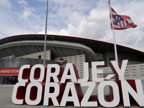 A sign reading "Courage and heart" stands outside Spanish football club Atletico Madrid's Wanda Metropolitano stadium in Madrid on April 19, 2021.