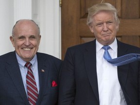 In this file photo taken on November 20, 2016 President-elect Donald Trump meets with former New York City Mayor Rudy Giuliani at the clubhouse of the Trump National Golf Club in Bedminster, New Jersey.