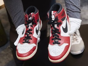 A Sotheby's staff holds a pair of "Air Jordan 1" shoes worn by NBA champion Michael Jordan during his rookie season in 1984-85 at the Chicago Bulls, during a preview for the "Gamers Only" auction sale in Geneva, Switzerland, April 28, 2021.