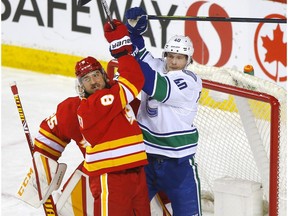 Calgary Flames' Chris Tanev battles Vancouver Canucks star Elias Pettersson in first period action at the Scotiabank Saddledome in Calgary on in Calgary on Monday, January 18, 2021. Darren Makowichuk/Postmedia