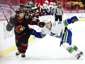 Vancouver Canucks' Nils Hoglander, right, and Ottawa Senators' Victor Mete battle for the puck during first period NHL action in Ottawa on Wednesday, April 28, 2021.
