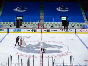 An arena worker removes a net after the Canucks' game against the Flames was postponed March 31.