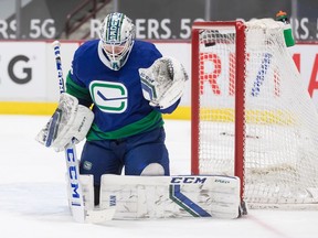 The puck bounces off the post behind Canucks goalie Thatcher Demko and stays out during Thursday’s NHL game against the Ottawa Senators at Rogers Arena.