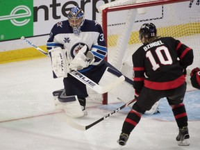 Winnipeg Jets goalie Connor Hellebuyck (37) makes a save on a shot from Ottawa Senators left wing Ryan Dzingel (10) in the third period at the Canadian Tire Centre in Ottawa on Monday, April 12, 2021.