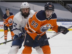 The Edmonton Oilers' Ryan Nugent-Hopkins (93) battles the Toronto Maple Leafs' Zach Bogosian (22) during first period NHL action at Rogers Place, in Edmonton Saturday Feb. 27, 2021. Photo by David Bloom