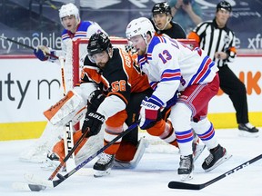 Philadelphia Flyers' Erik Gustafsson (56) and New York Rangers' Alexis Lafrenière (13) battle for the puck during the second period on Feb. 24, 2021, in Philadelphia.
