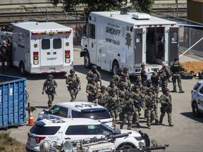 Tactical law enforcement officers move through the Valley Transportation Authority (VTA) light-rail yard where a mass shooting occurred on May 26, 2021 in San Jose, California. A VTA employee opened fire at the yard, with preliminary reports indicating nine people dead including the gunman. (Photo by Philip Pacheco/Getty Images)