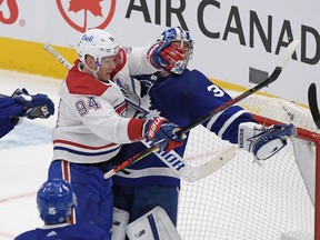 Toronto Maple Leafs goalie Jack Campbell (36) holds the puck in his glove as he is bodychecked by Montreal Canadiens forward Corey Perry earlier this season.